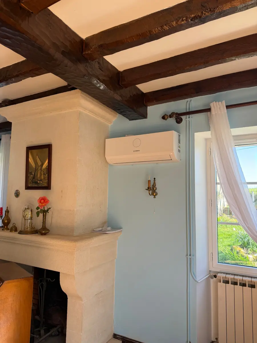 Climatisation murale Bosch installée par F2C dans un salon à poutres apparentes