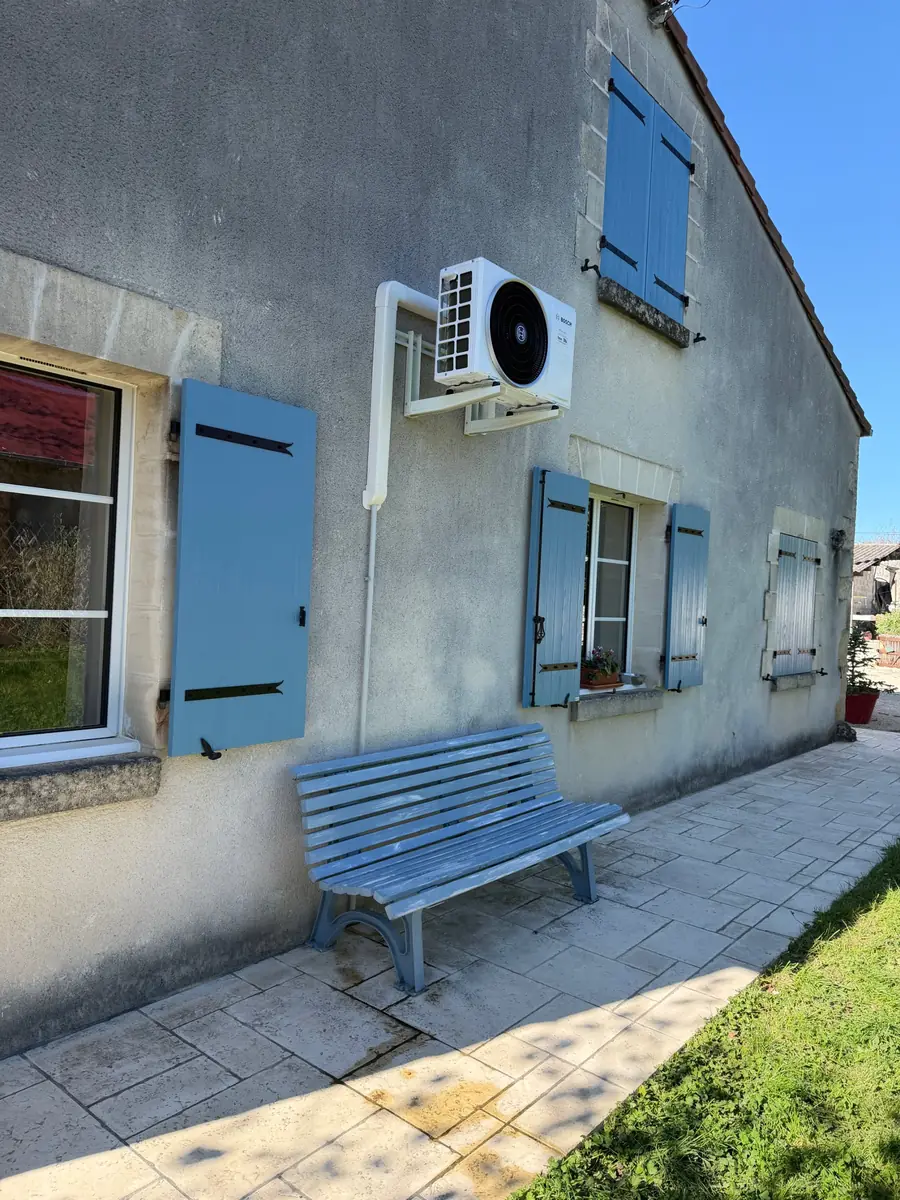 Groupe extérieur de climatisation Bosch posé par F2C contre une façade à volets