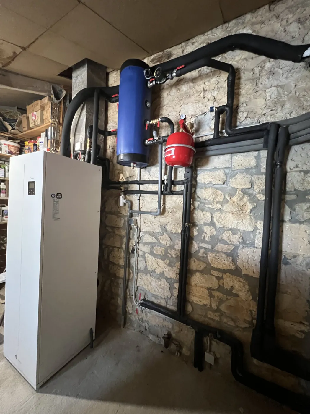 Pompe à chaleur Midea et ballon installés par F2C dans une chaufferie aux murs de pierre